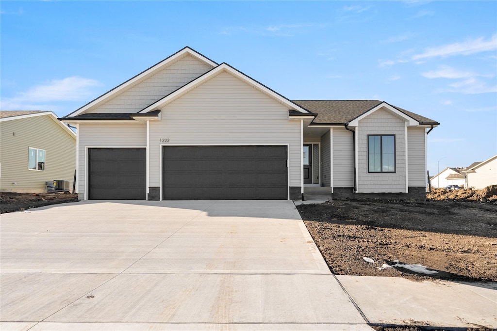 view of front of property featuring a garage and central AC