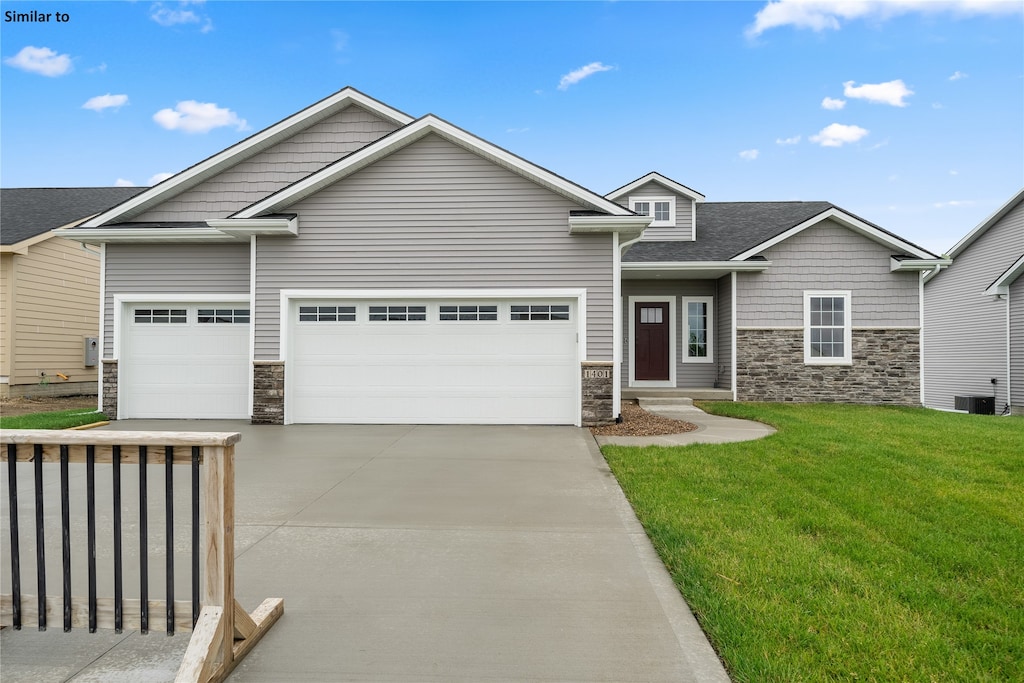 craftsman inspired home featuring central air condition unit, a front lawn, and a garage