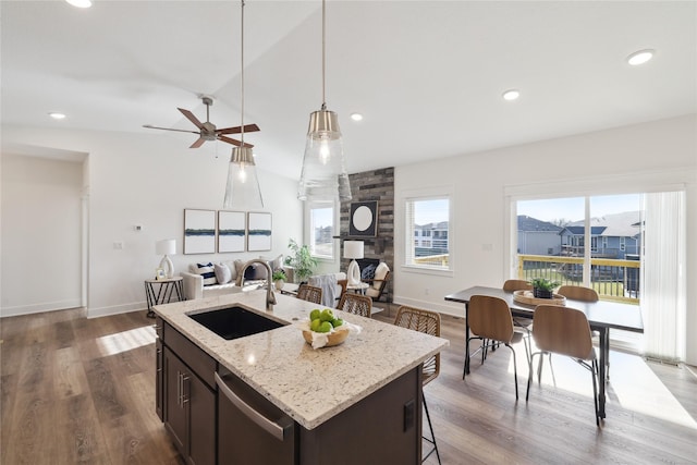 kitchen featuring dishwasher, pendant lighting, an island with sink, and sink