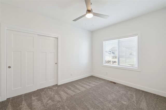 unfurnished bedroom featuring carpet, ceiling fan, and a closet