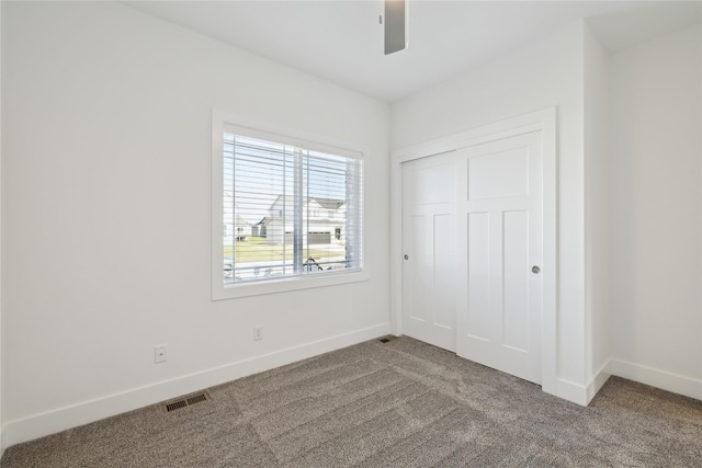 unfurnished bedroom with carpet flooring, ceiling fan, and a closet