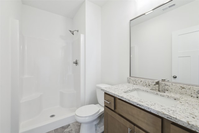 bathroom featuring a shower, vanity, and toilet