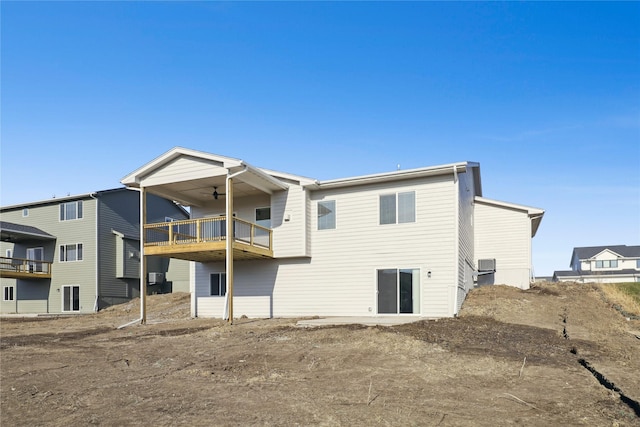 back of property featuring ceiling fan and a balcony