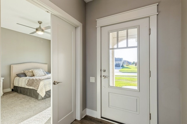 entryway with ceiling fan, dark carpet, and a wealth of natural light