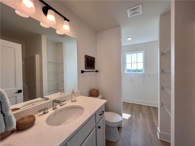 bathroom featuring vanity, toilet, and hardwood / wood-style flooring