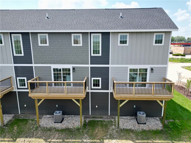 rear view of property featuring a wooden deck and cooling unit