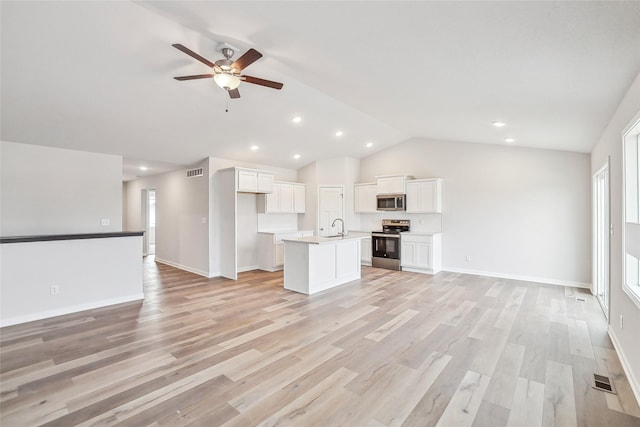 unfurnished living room with a wealth of natural light, ceiling fan, light wood-type flooring, and lofted ceiling