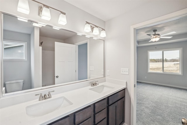 bathroom with toilet, vanity, and ceiling fan