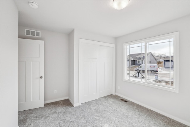 unfurnished bedroom with a closet and carpet floors