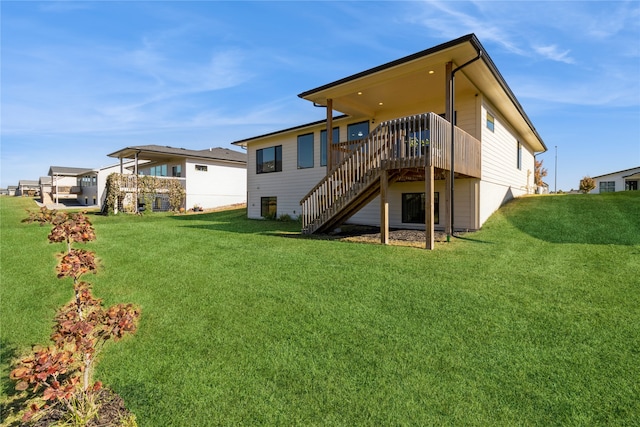 rear view of property featuring a deck and a lawn