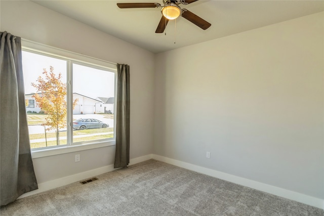 unfurnished room with light colored carpet and ceiling fan