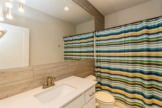 bathroom with vanity, decorative backsplash, toilet, and walk in shower