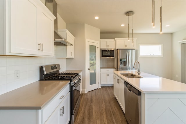 kitchen featuring appliances with stainless steel finishes, white cabinetry, sink, and hanging light fixtures