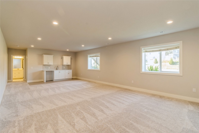 unfurnished living room featuring light carpet