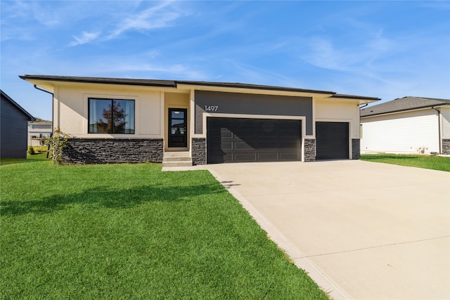 prairie-style home featuring a front yard and a garage