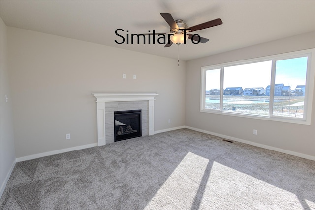 unfurnished living room featuring carpet floors, a fireplace, visible vents, a ceiling fan, and baseboards