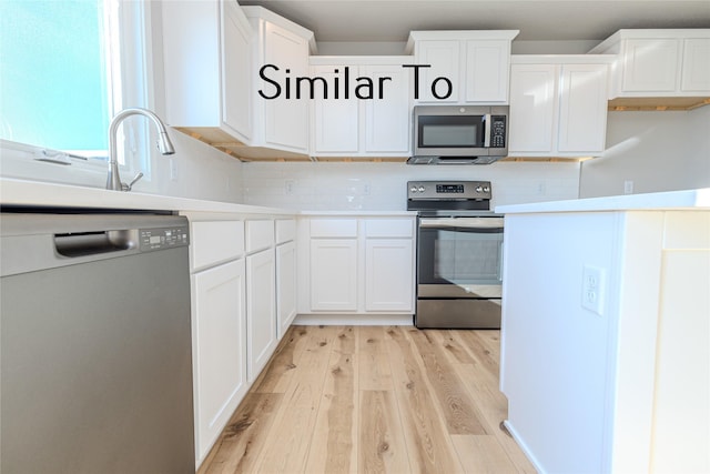 kitchen with stainless steel appliances, white cabinetry, light countertops, light wood-type flooring, and backsplash