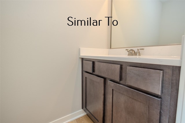 bathroom featuring wood finished floors, vanity, and baseboards