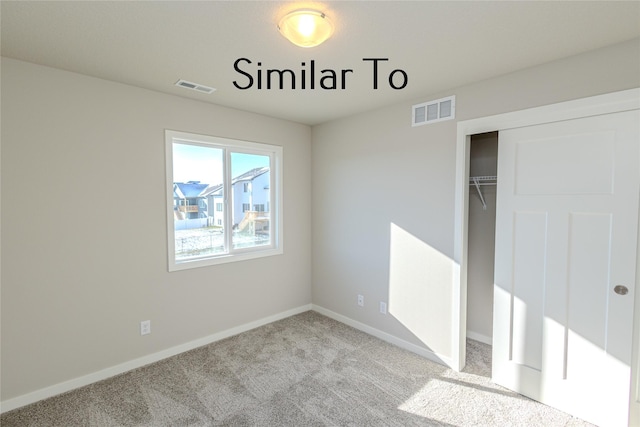 unfurnished bedroom with baseboards, a closet, visible vents, and light colored carpet