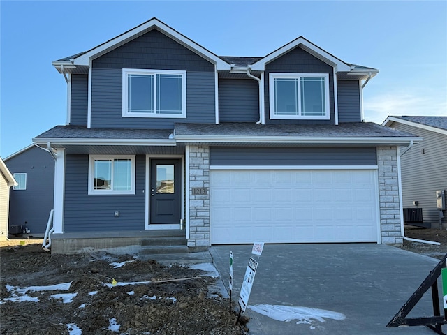 front of property featuring a garage and central AC unit