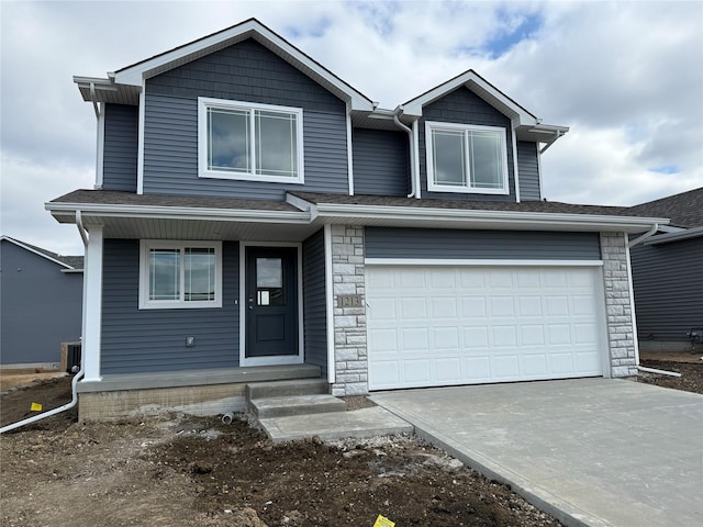 view of front of property featuring an attached garage, stone siding, a shingled roof, and central AC unit