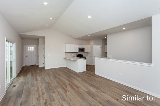 unfurnished living room with sink, lofted ceiling, and light hardwood / wood-style flooring