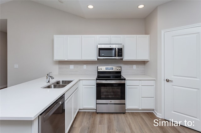 kitchen with appliances with stainless steel finishes, white cabinetry, tasteful backsplash, and sink