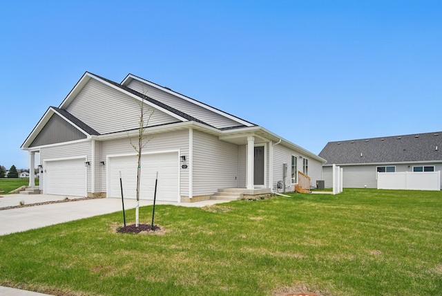 view of front facade featuring driveway, a front yard, an attached garage, and central air condition unit