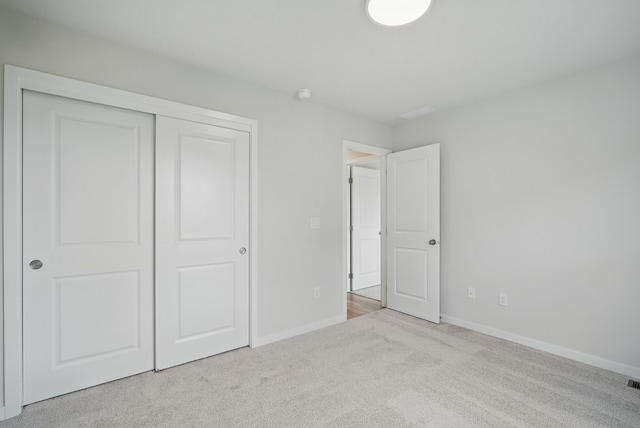 unfurnished bedroom featuring a closet, carpet flooring, and baseboards