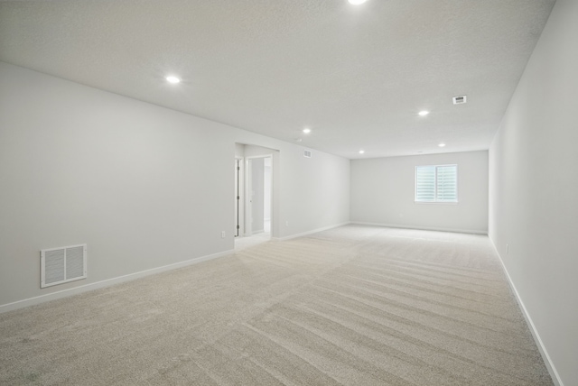 empty room with light colored carpet, visible vents, recessed lighting, and baseboards