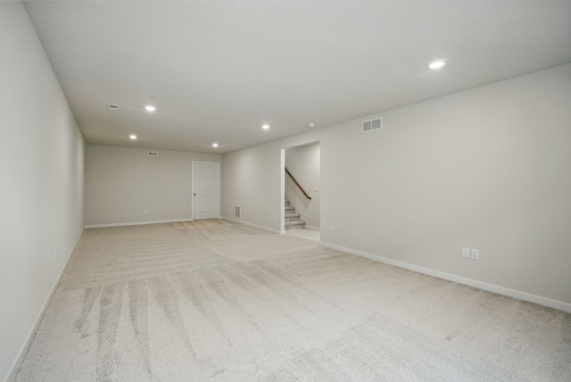 basement featuring visible vents, recessed lighting, light carpet, and stairs