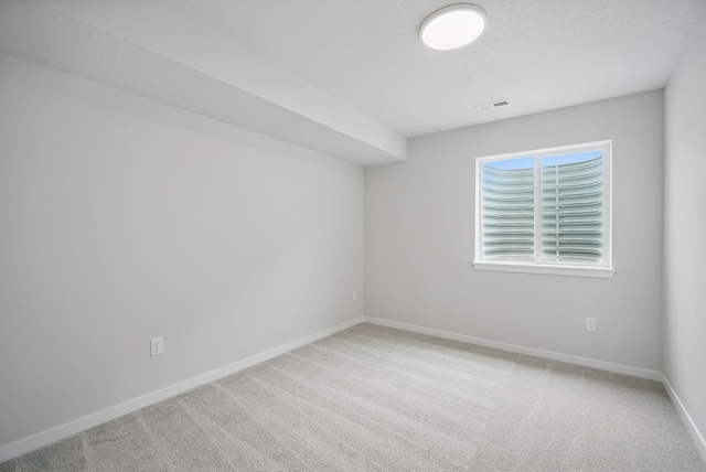 unfurnished room with visible vents, carpet floors, and baseboards