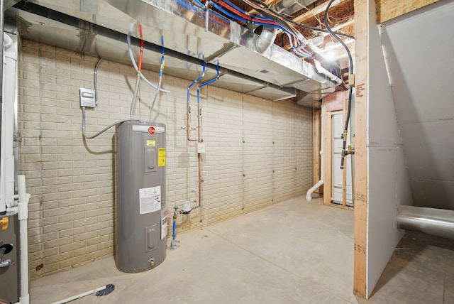 unfinished basement featuring brick wall and electric water heater
