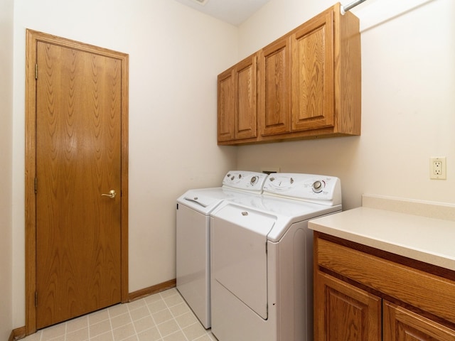 clothes washing area featuring independent washer and dryer and cabinets