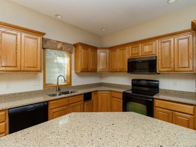 kitchen with sink, black appliances, light stone countertops, and backsplash