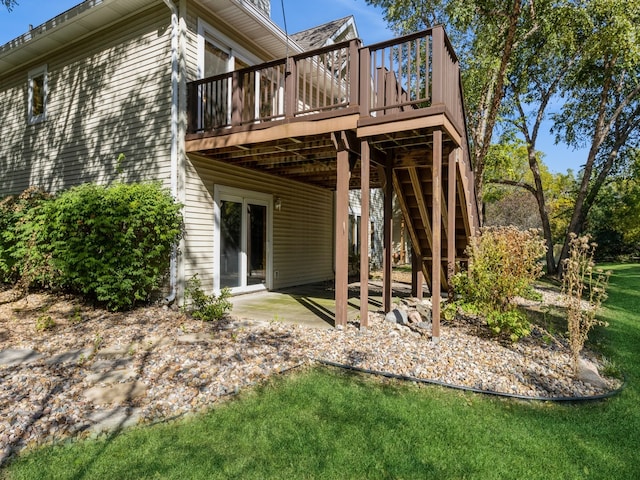 back of property with a wooden deck, a patio, and a lawn