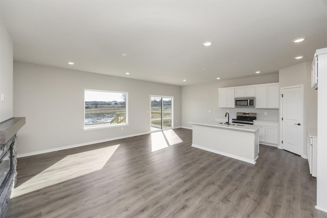 kitchen with dark wood-style floors, appliances with stainless steel finishes, open floor plan, and white cabinetry