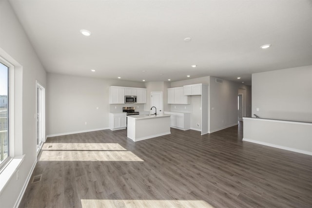 unfurnished living room with dark wood finished floors, visible vents, recessed lighting, and a sink