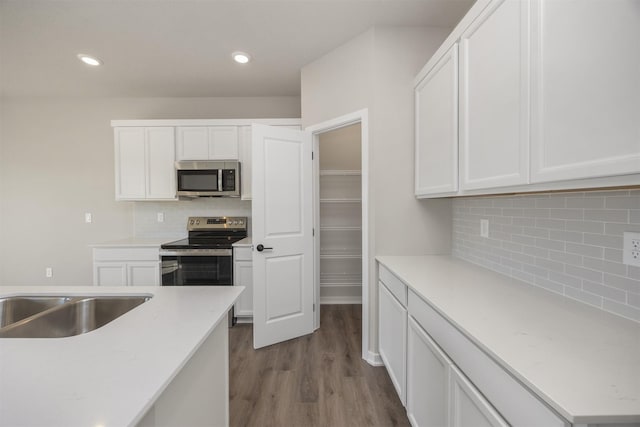 kitchen with white cabinetry, recessed lighting, dark wood-style floors, and stainless steel appliances