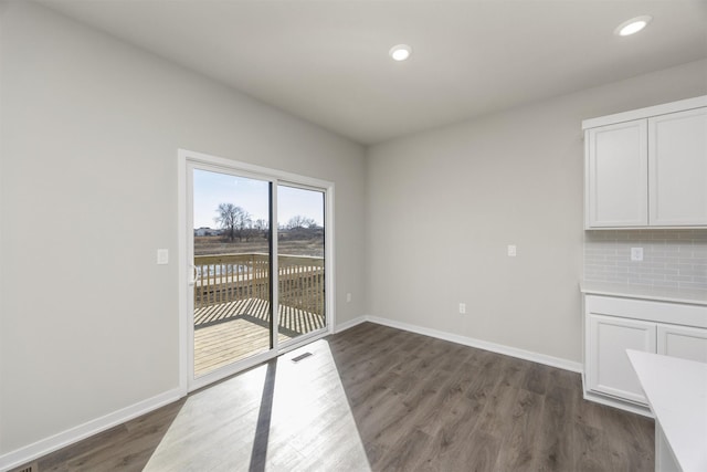 unfurnished dining area with recessed lighting, visible vents, baseboards, and dark wood-type flooring