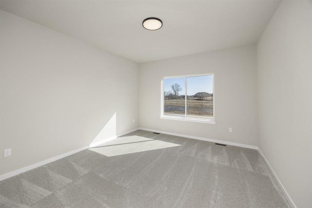 carpeted empty room with visible vents and baseboards