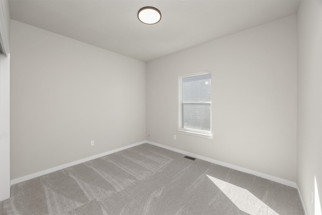 carpeted empty room with visible vents and baseboards