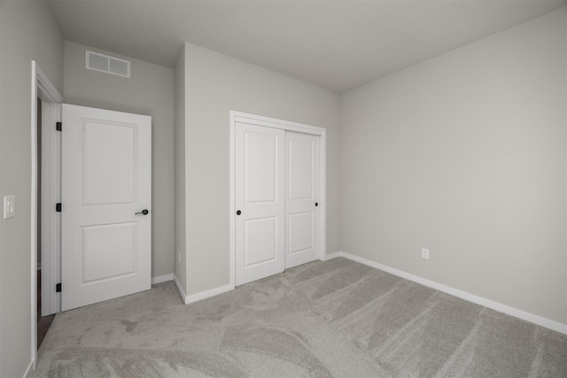 unfurnished bedroom featuring a closet, visible vents, carpet flooring, and baseboards