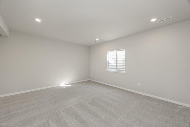 spare room with light carpet, recessed lighting, and baseboards