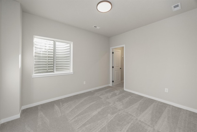 unfurnished room featuring carpet flooring, baseboards, and visible vents