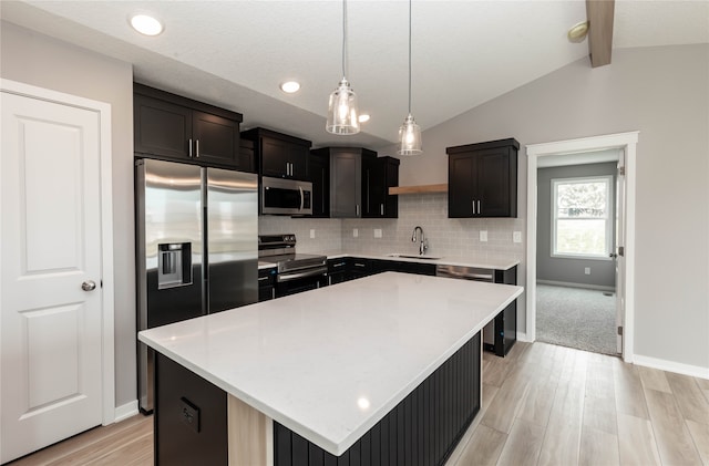 kitchen featuring tasteful backsplash, appliances with stainless steel finishes, sink, a kitchen island, and lofted ceiling with beams