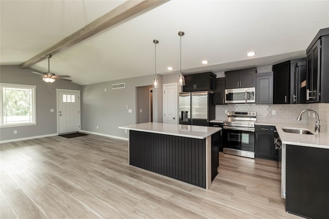 kitchen with tasteful backsplash, sink, light wood-type flooring, a center island, and stainless steel appliances