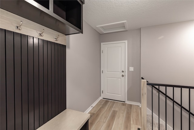 mudroom featuring a textured ceiling and light hardwood / wood-style flooring