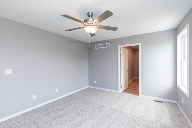 spare room with light colored carpet and ceiling fan