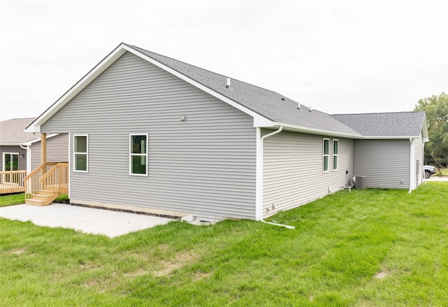 rear view of house with a yard, a patio area, and central AC unit